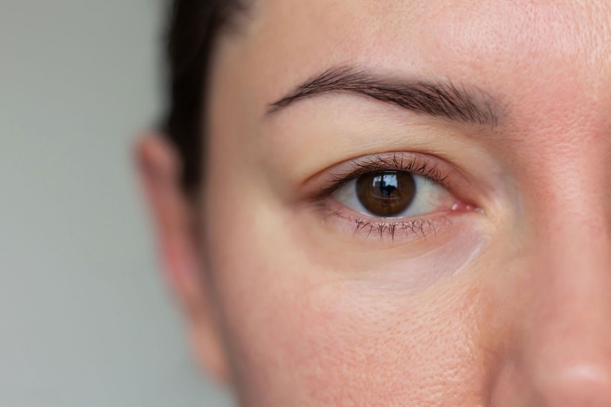 Close-up of a woman's eye and cheek, showing skin texture