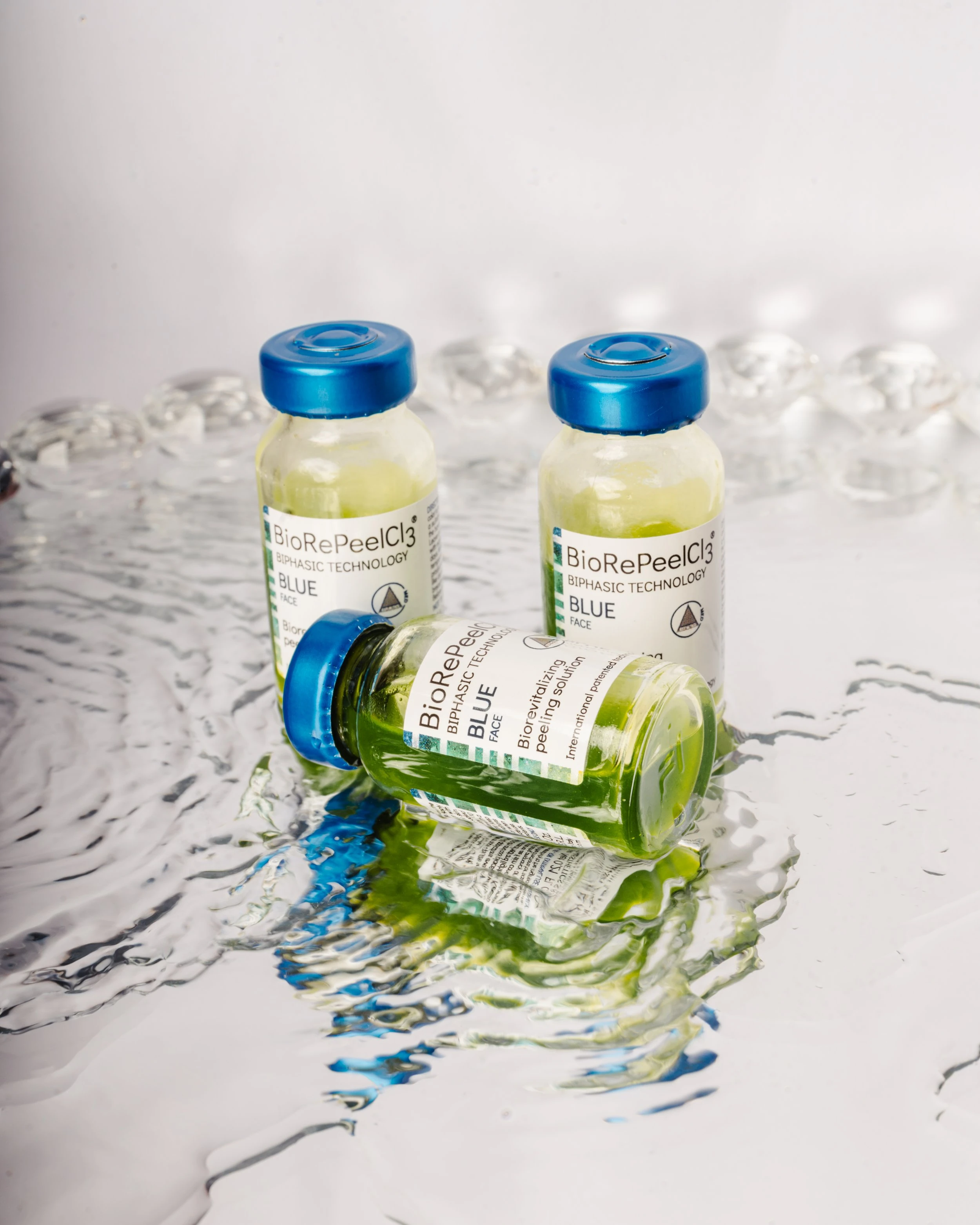 Three BioRePeelCl3 Blue face vials, one lying in water